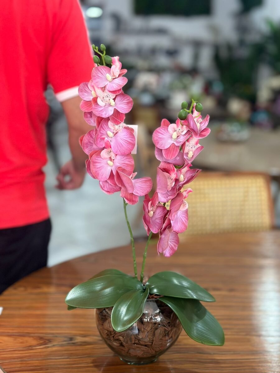 O Arranjo de Orquídea Artificial Rosa com 2 hastes é uma peça elegante e sofisticada para decoração. Com flores em um tom rosa delicado, este arranjo traz um toque de frescor e beleza a qualquer ambiente. Feito de material de alta qualidade, apresenta detalhes realistas que imitam as orquídeas naturais. Ideal para mesas, estantes ou como centro de mesa, requer pouca manutenção e mantém sua aparência vibrante ao longo do tempo. Perfeito para quem busca estilo sem a necessidade de cuidados especiais.